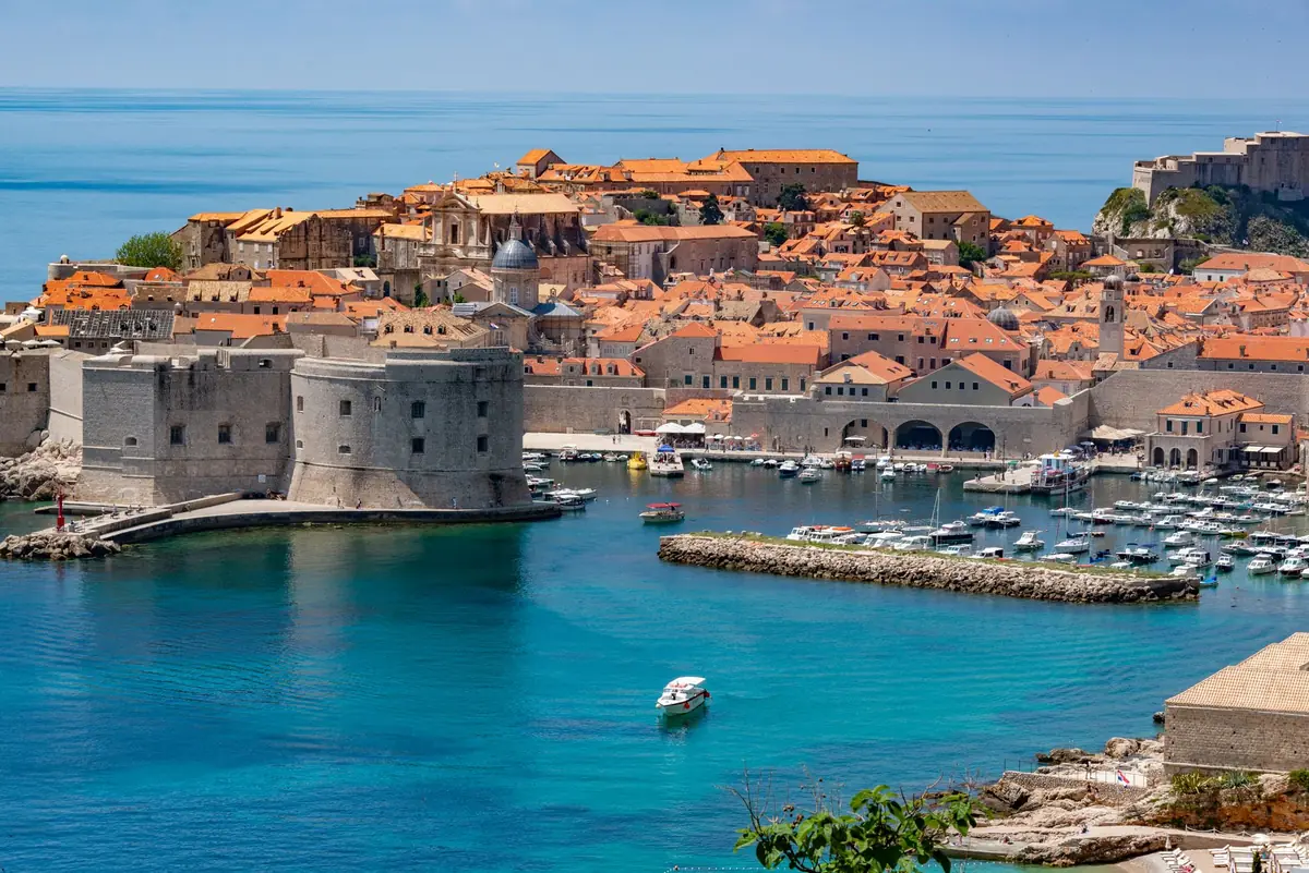 The old walled harbor town of Dubrovnik from above, red roofs on blue water