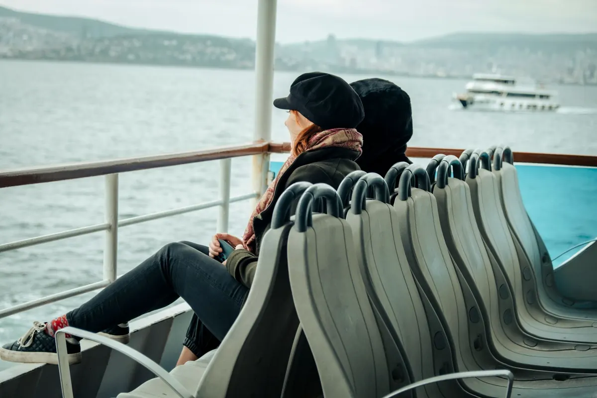 Two travelers sitting on deck chairs, watching the sea go by without a plan for the day