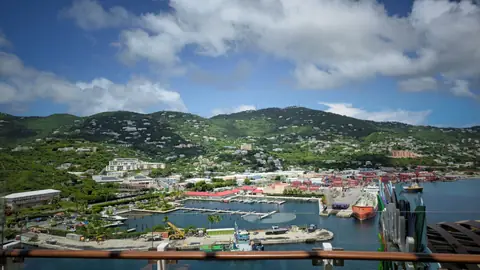 The harbor at Charlotte Amalie in St. Thomas seen from a ship rail, green hills behind the port